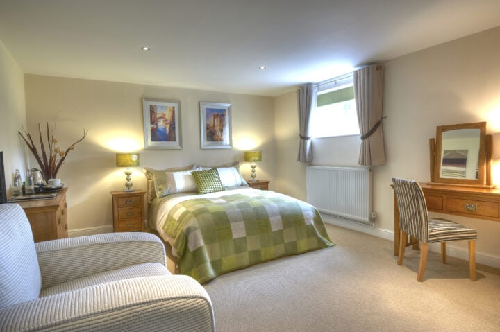 A bedroom with a bed and a chair.