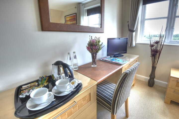 A desk with a cup of coffee and a cup of tea.