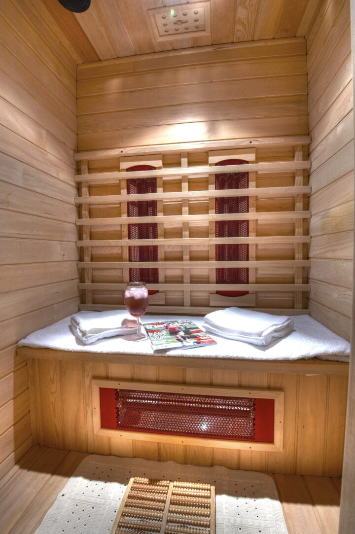 An infrared sauna room with a bed and towels.