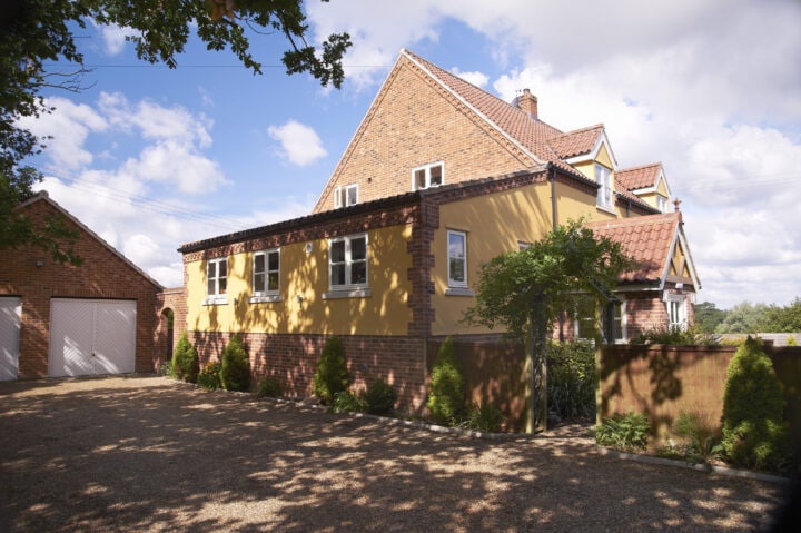 A yellow house with a garage in front of it.